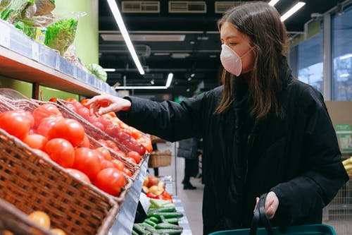 Woman using a disposable mask while going shopping for groceries